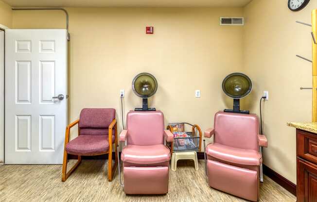 a room with three chairs and two fans