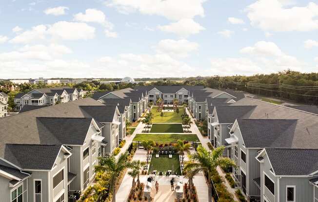 an aerial view of a row of houses with a grassy area and palm trees at Palm Grove in Ellenton, FL 34222