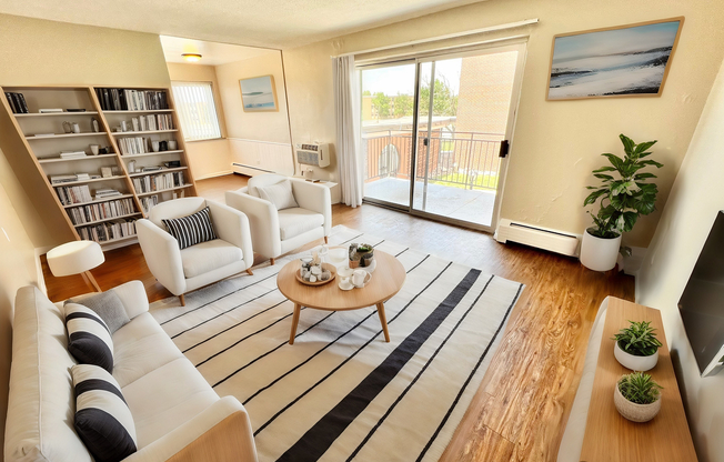 Bright and inviting living room featuring sleek furnishings, elegant bookshelf, and a spacious balcony view, perfect for modern apartment living.