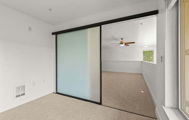 A room with a sliding door and a ceiling fan.