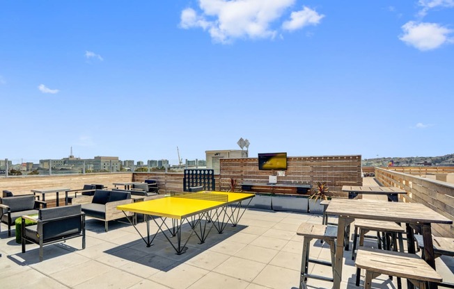 a rooftop patio with tables and chairs and a television at L Seven, California