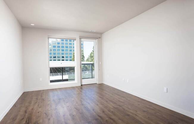 Empty room with a large window and wooden floor. at Elements Apartments*, Irvine, CA, 92612