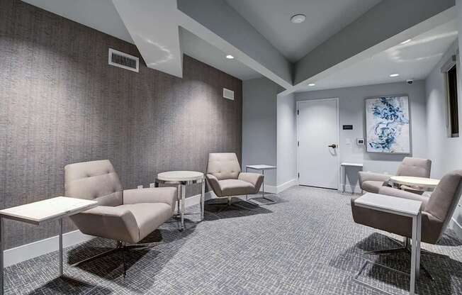 A waiting room with grey carpet and chairs.