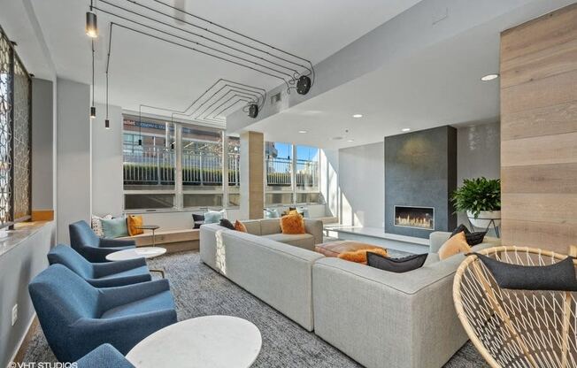 a living room with a couch and chairs in front of a fireplace