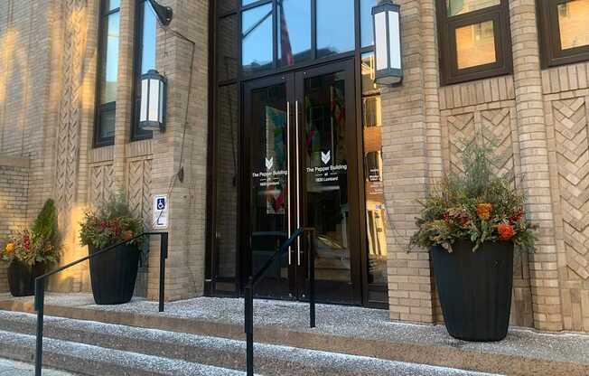 A building entrance with a glass door and a sign on the wall.