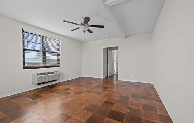 A room with a ceiling fan and a window with blinds.