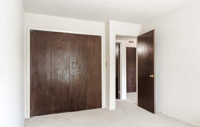 A room with a brown door and a white wall.