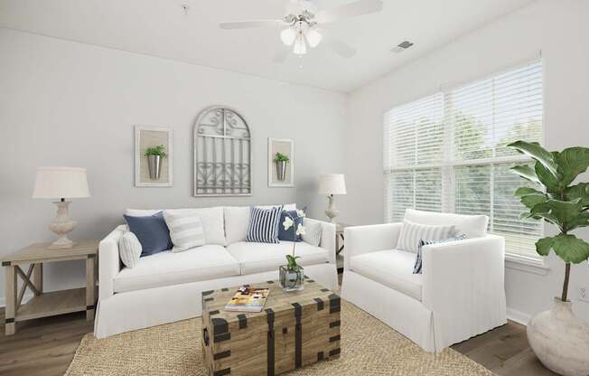 A living room with white furniture and a ceiling fan.