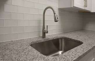 A modern kitchen sink with a chrome faucet at The Madison Apartments and Townhomes, Georgia