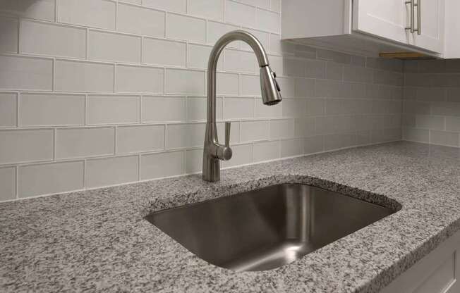 A modern kitchen sink with a chrome faucet.