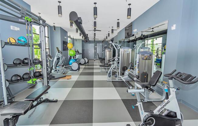 Long gym walkway with checkered floors showing weight and cardio equipment on both sides