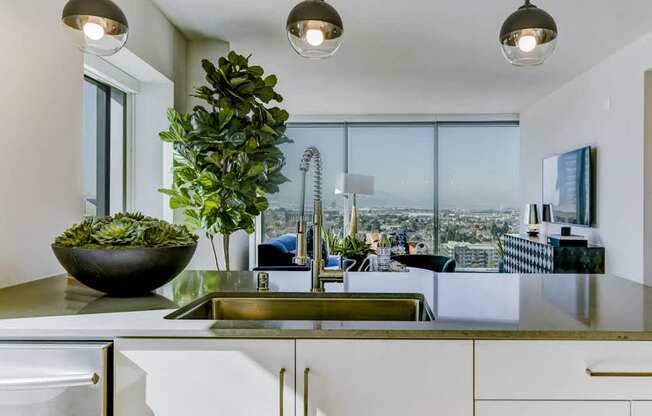 A modern kitchen with a large window overlooking the city.