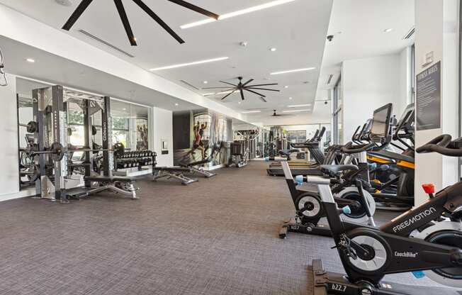 a spacious fitness center with cardio machines and other exercise equipment