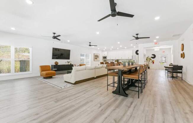a living room and dining room with white walls and wood floors