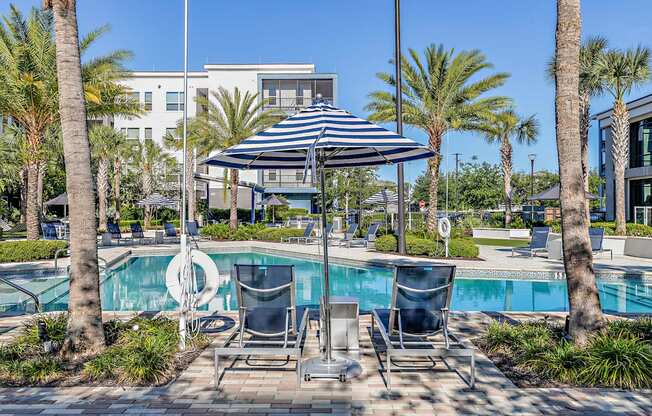 a swimming pool with chairs and umbrellas