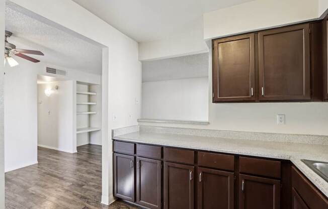 A kitchen with brown cabinets and a white counter.