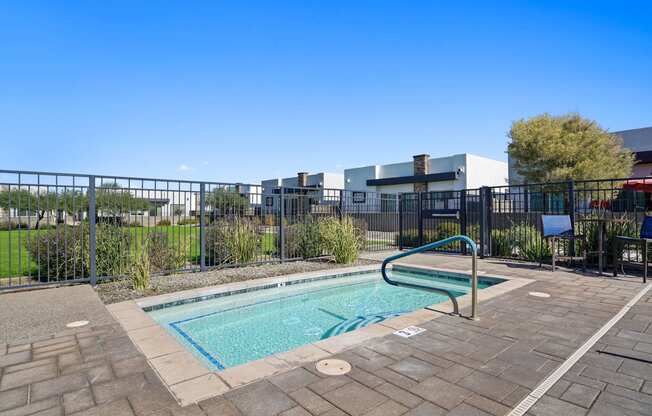 a swimming pool with a metal fence around it and a building in the background