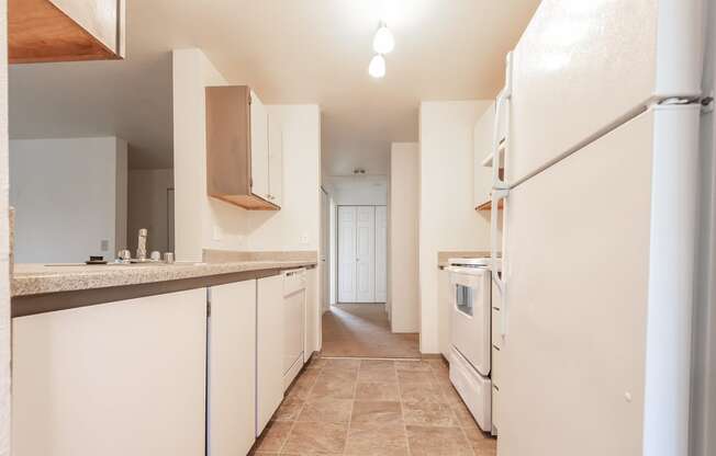 a kitchen with white cabinets and white appliances
