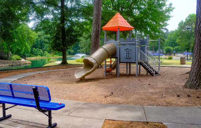 a playground with a slide and a climbing structure in a park