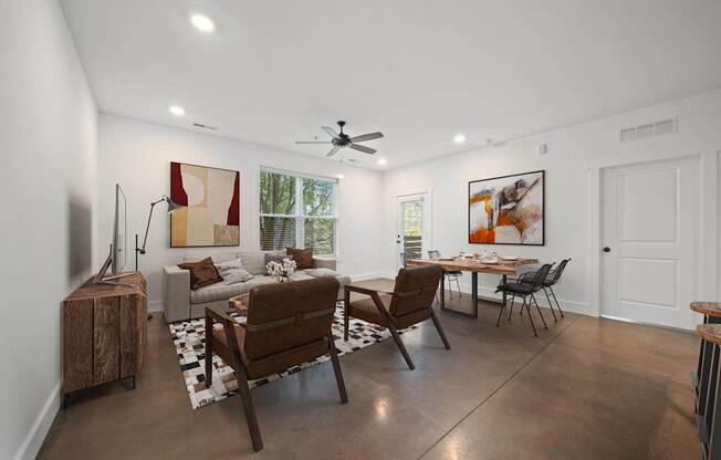 A living room with a brown sofa, a wooden table, and a television at River Mill Lofts & Skyloft in Asheville, NC