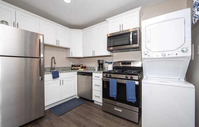 a kitchen with white cabinets and stainless steel appliances and a stainless steel refrigerator