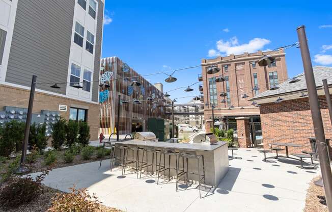 a patio with a bar and chairs in front of a building