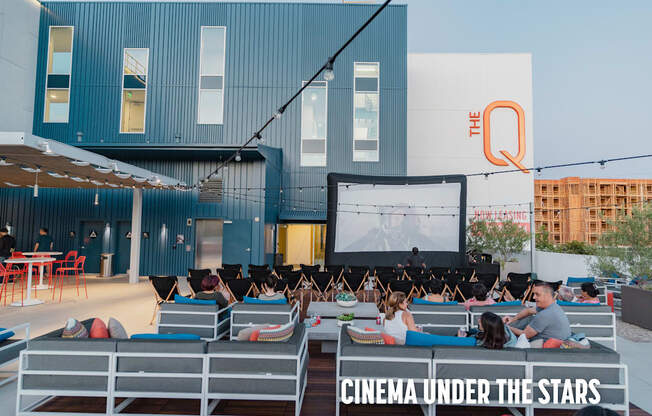 People are watching a movie under the stars in an outdoor cinema.