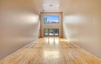 A long hallway with wooden floors and white walls.