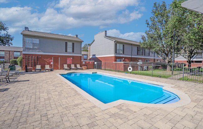 Our sparkling pool with poolside loungers surrounded by apartment buildings at Magnolia apartments in Shreveport, LA