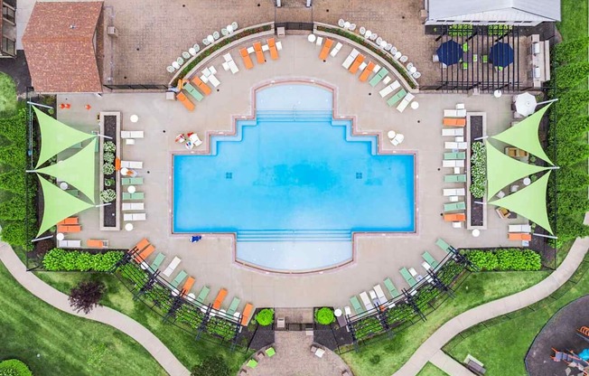 An aerial view of a pool surrounded by lounge chairs and umbrellas.