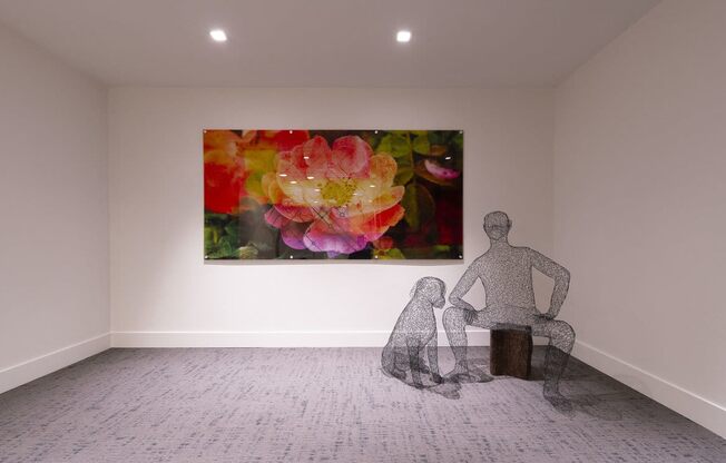 a sculpture of a man and a dog in a room with a painting of flowers