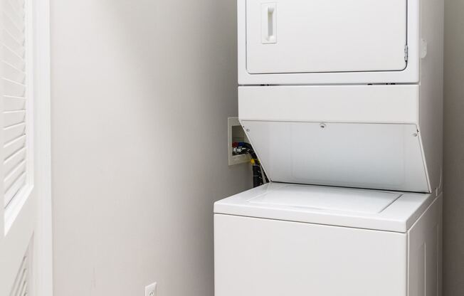 A white oven and drier are stacked on top of each other.