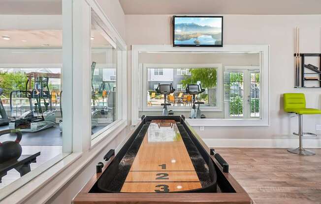 A room with a bowling alley and a television mounted on the wall.