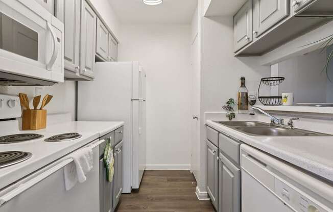 A kitchen with white appliances and a white counter top.