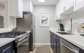 an open kitchen with stainless steel appliances and white counter tops