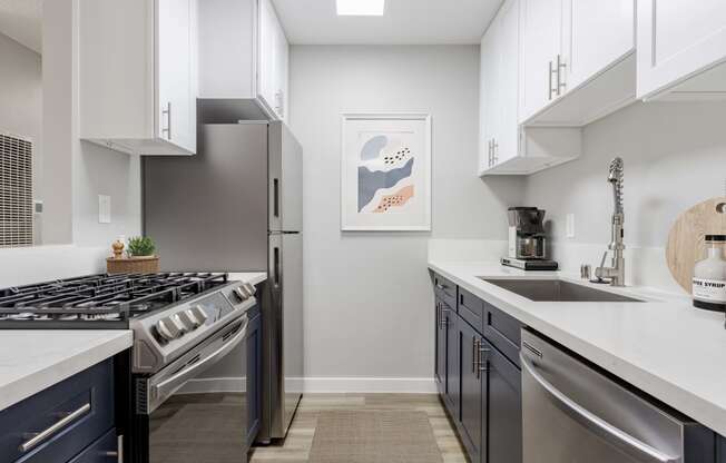 an open kitchen with stainless steel appliances and white counter tops