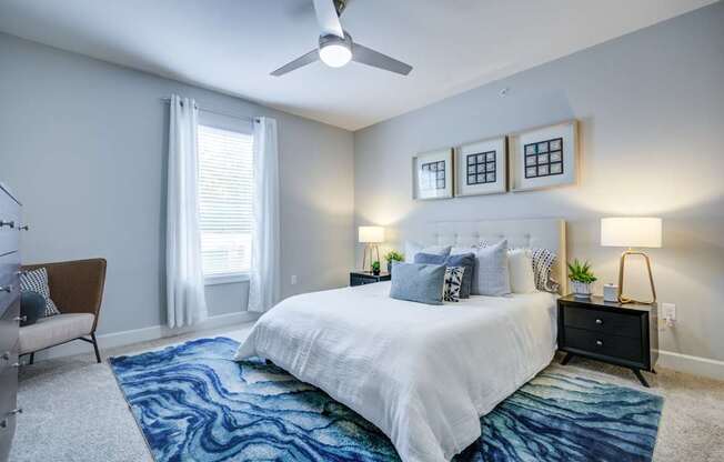 A bedroom with a large bed and a ceiling fan.