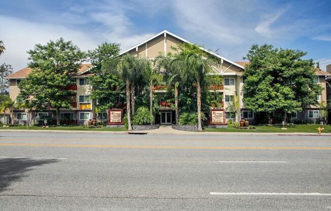 Pet Friendly Apartments in Woodland Hills, CA - Lombardi Apartments Exterior with Lush Greenery and Monument Signs