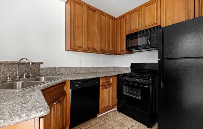 a kitchen with wood cabinets and black appliances