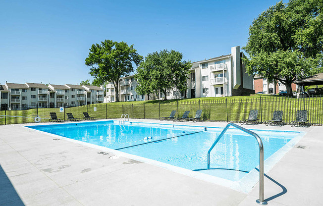 a swimming pool with an apartment building in the background