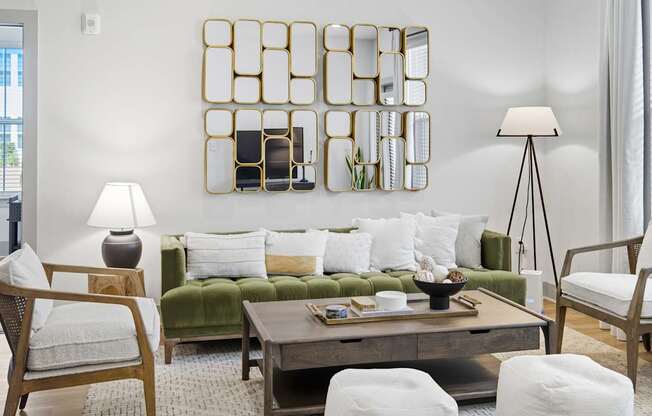 A modern living room with a green couch, a wooden coffee table, and a large mirror on the wall.