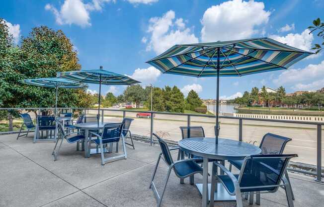 a patio with tables and chairs and umbrellas