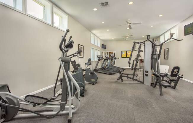 a gym with weights and cardio equipment in a building with windows at Highland Ridge Apartments, Kansas, 66210