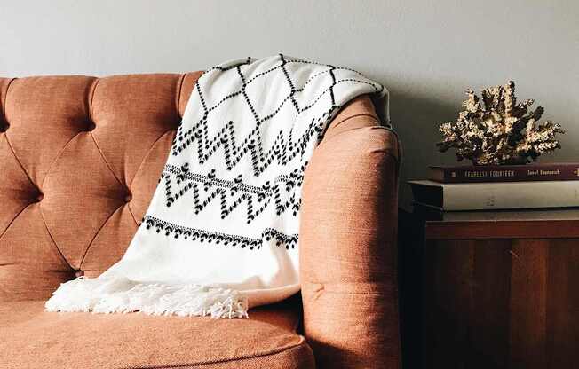 A living room with a couch, a chair, a coffee table, and a television.