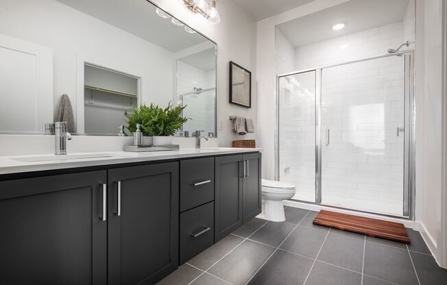 a black and white bathroom with a shower and sink