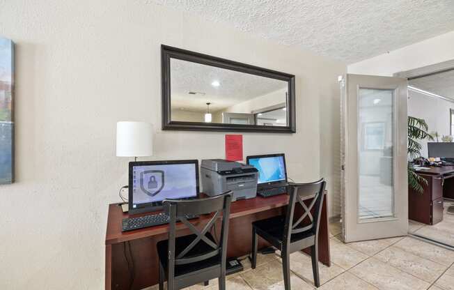 a home office with a desk with three computers on it