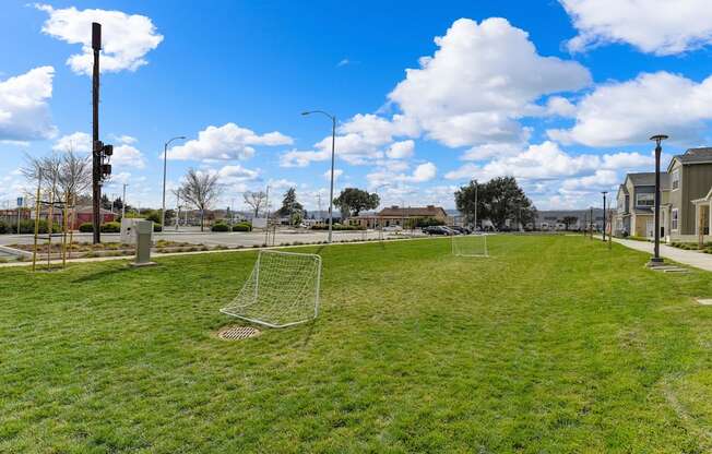 Grassy area with two smaller soccer goals set up. Sky is bright blue with large white clouds at Morgan Ranch Apartments, Morgan Hill, CA, 95037