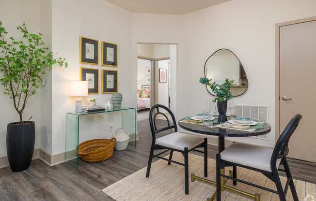 a living room with a table and chairs and a mirror