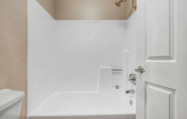 a white bathroom with a tub and a sink