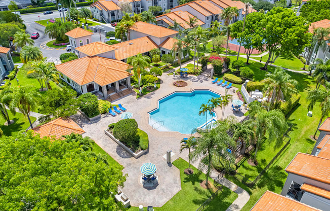 A swimming pool surrounded by palm trees and a small fountain.